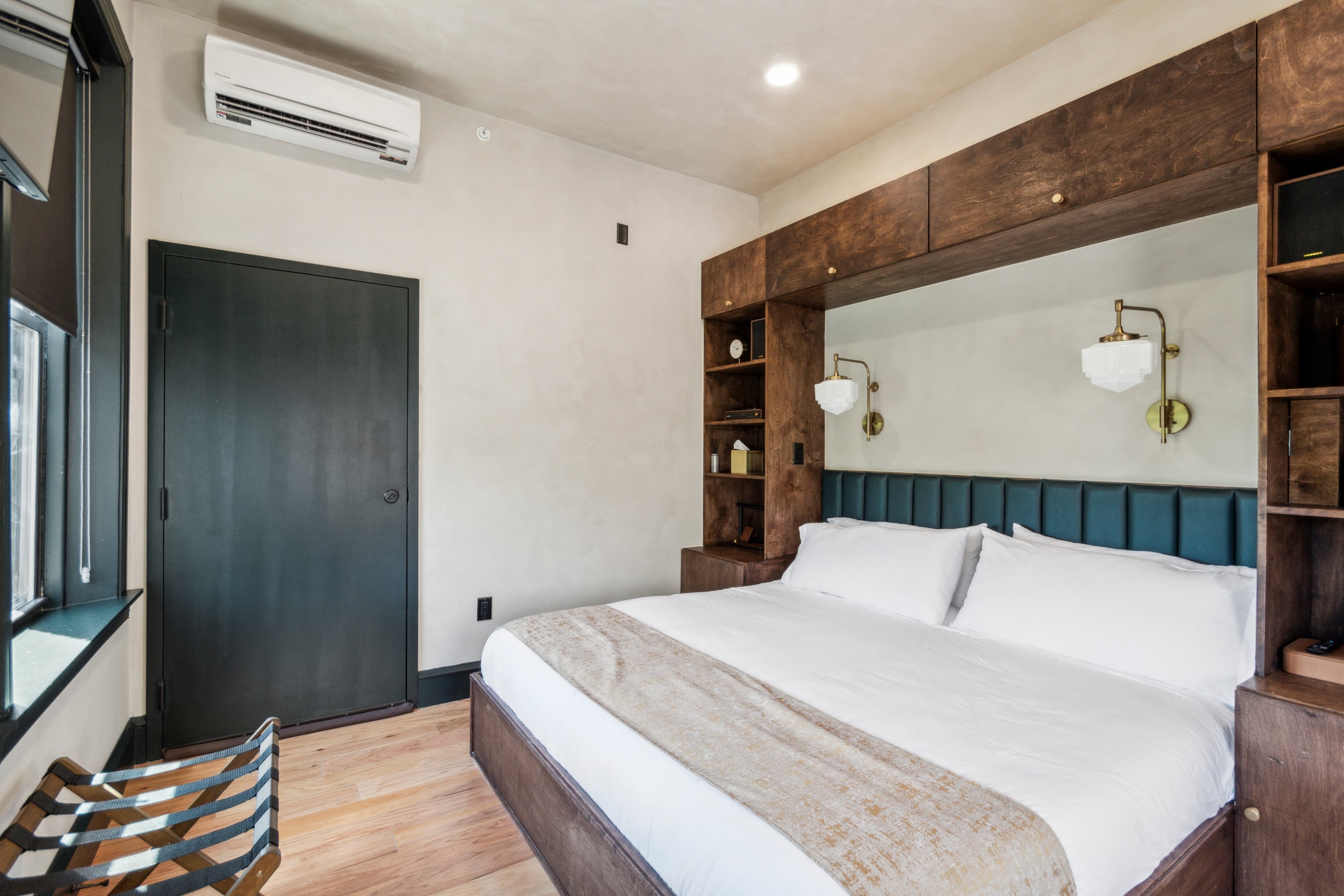 A King room at Society Hill Hotel — dark walnut bed, brass fixtures, morning light